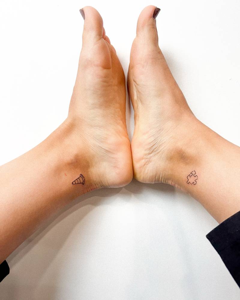 Traffic cone and puzzle piece tattooed on the ankles.