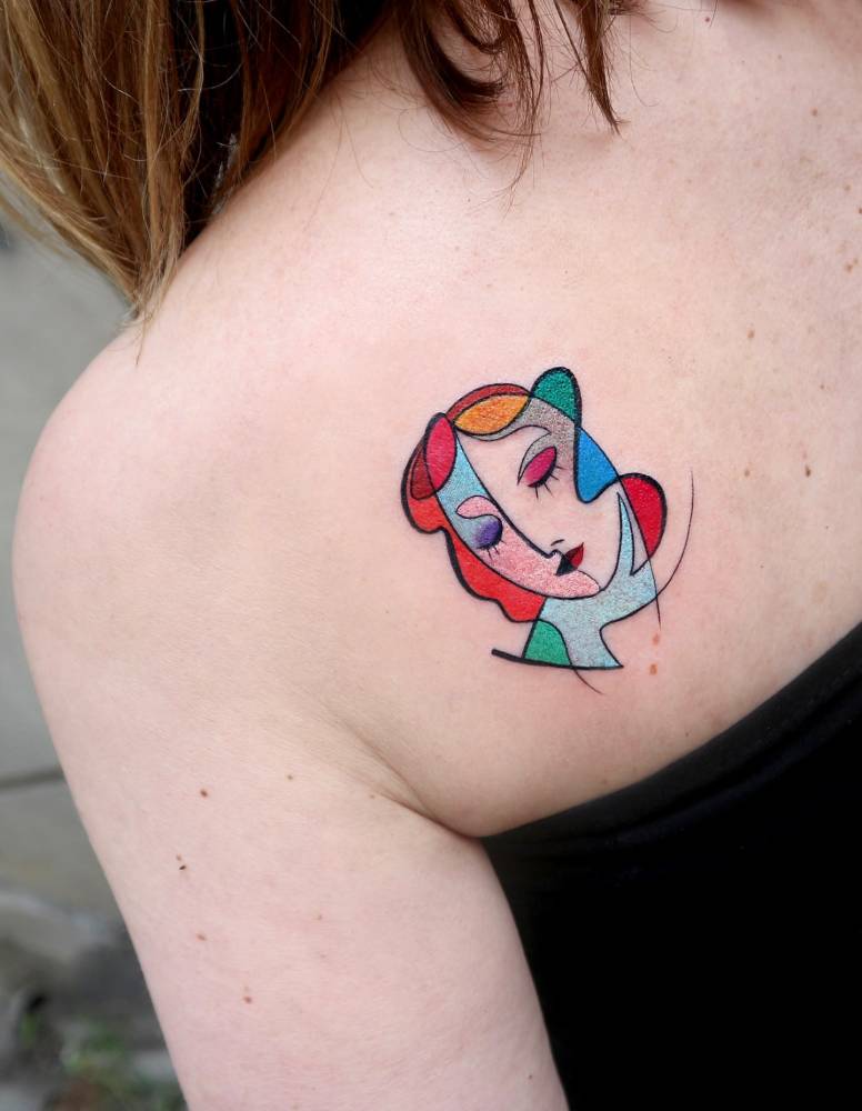 Cubism style woman portrait tattoo located on the shoulder blade.