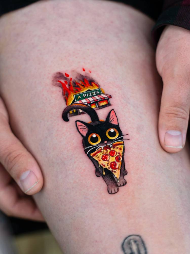 Cartoon style tattoo of a cat carrying a pizza located on the thigh.