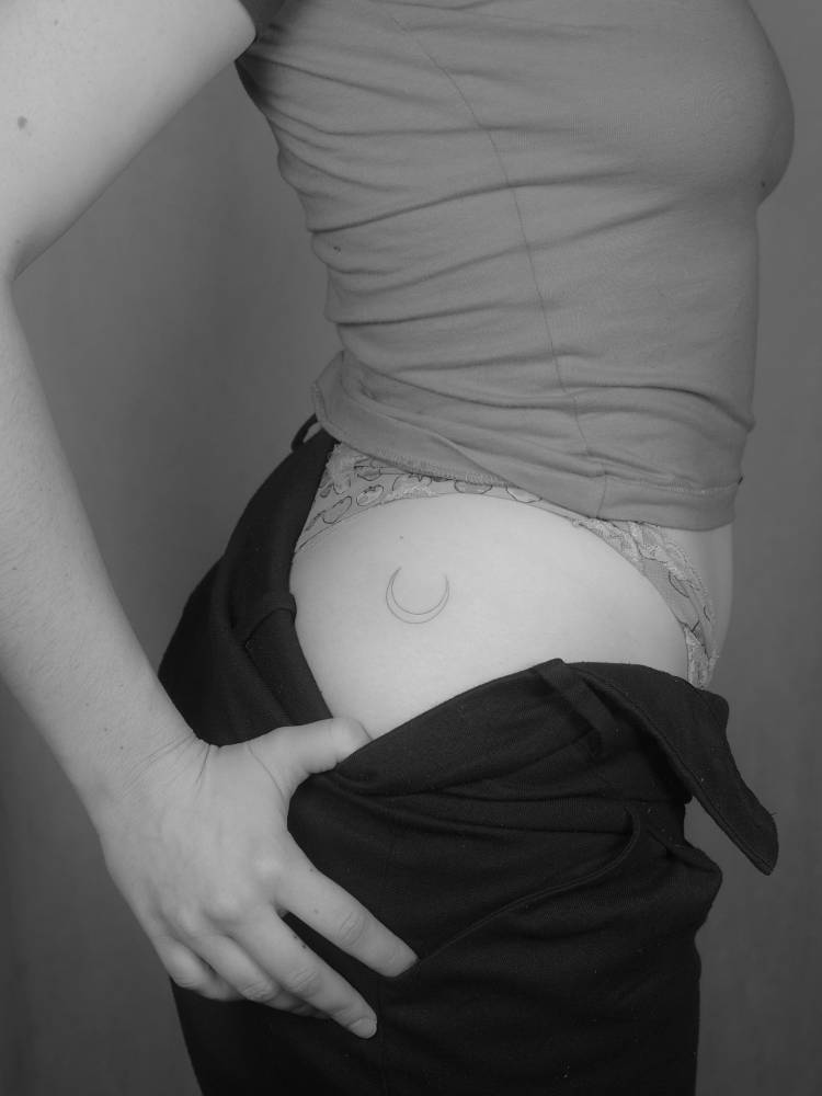 Fine line style minimalistic crescent moon tattoo done on the hip.