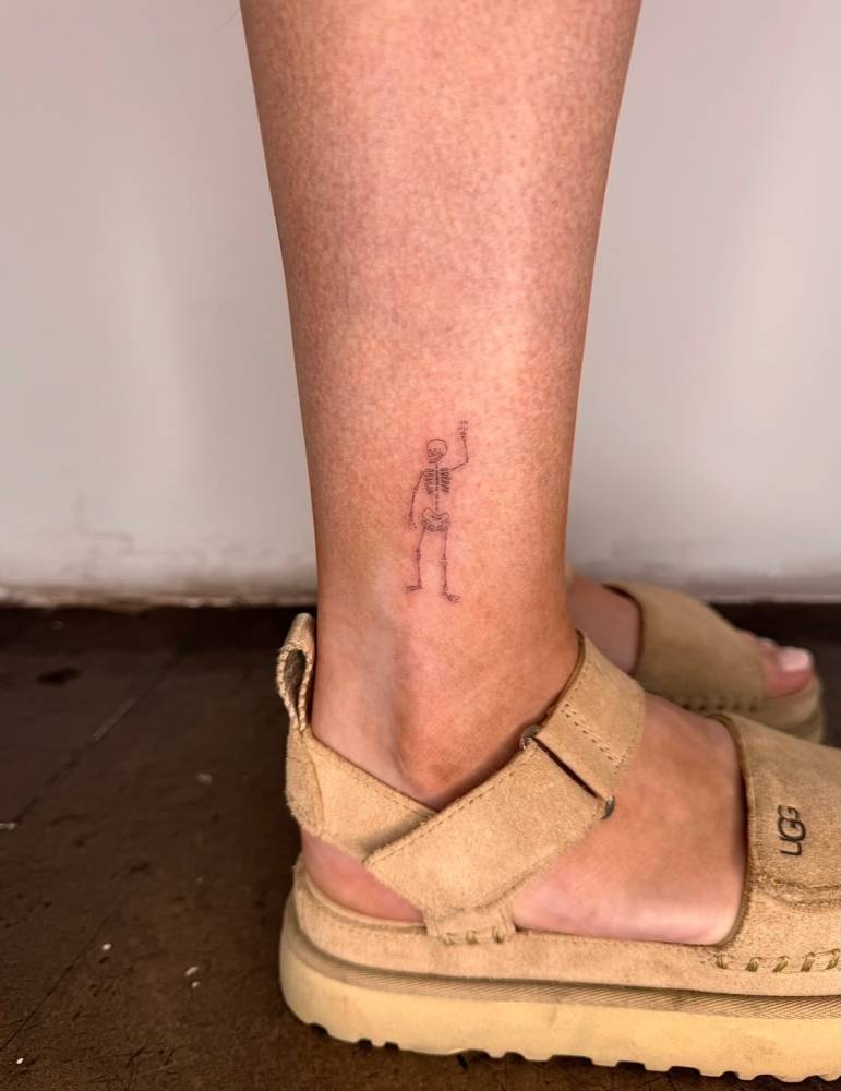 Single needle skeleton tattoo placed on the ankle.