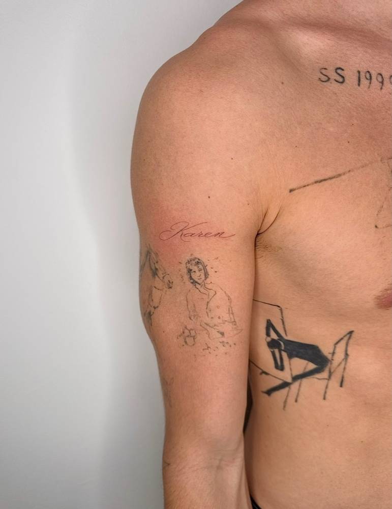 Lettering tattoo of the name "Karen" located on the upper arm.