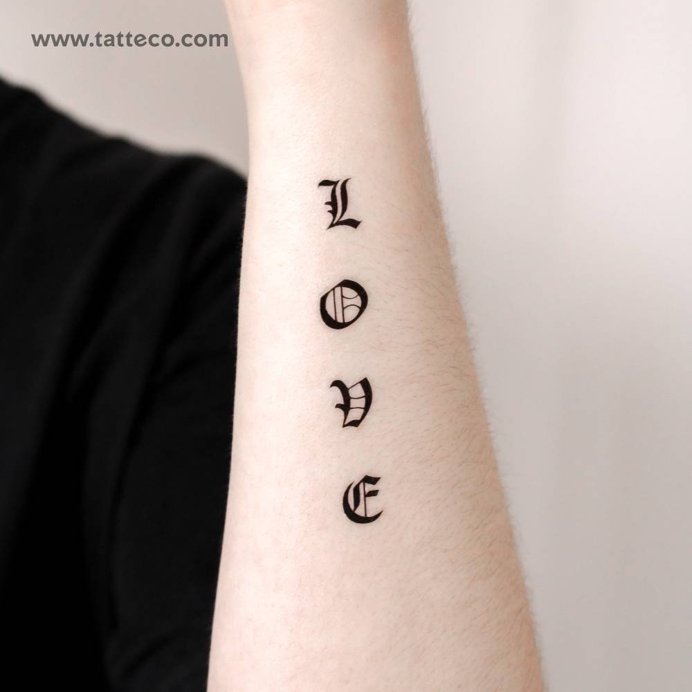 Gothic font word "love" temporary tattoo located on the wrist.