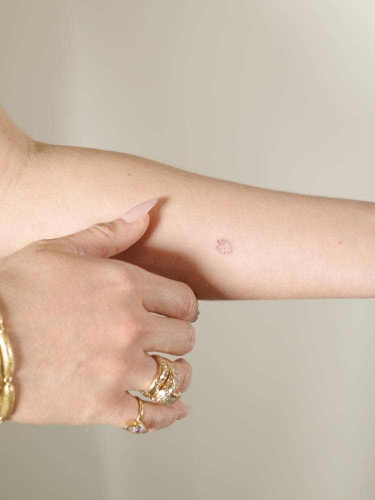 Tiny minimalist strawberry tattoo done on the inner forearm.