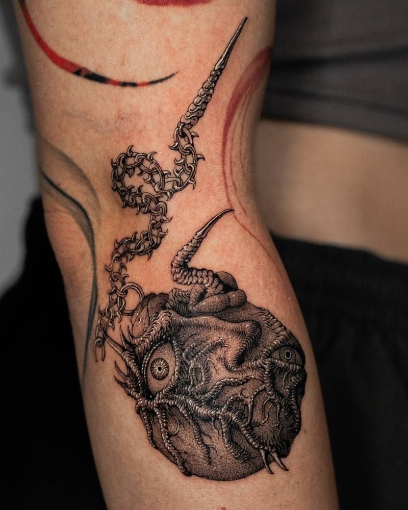 Berserker's Behelit tattoo located on the elbow,