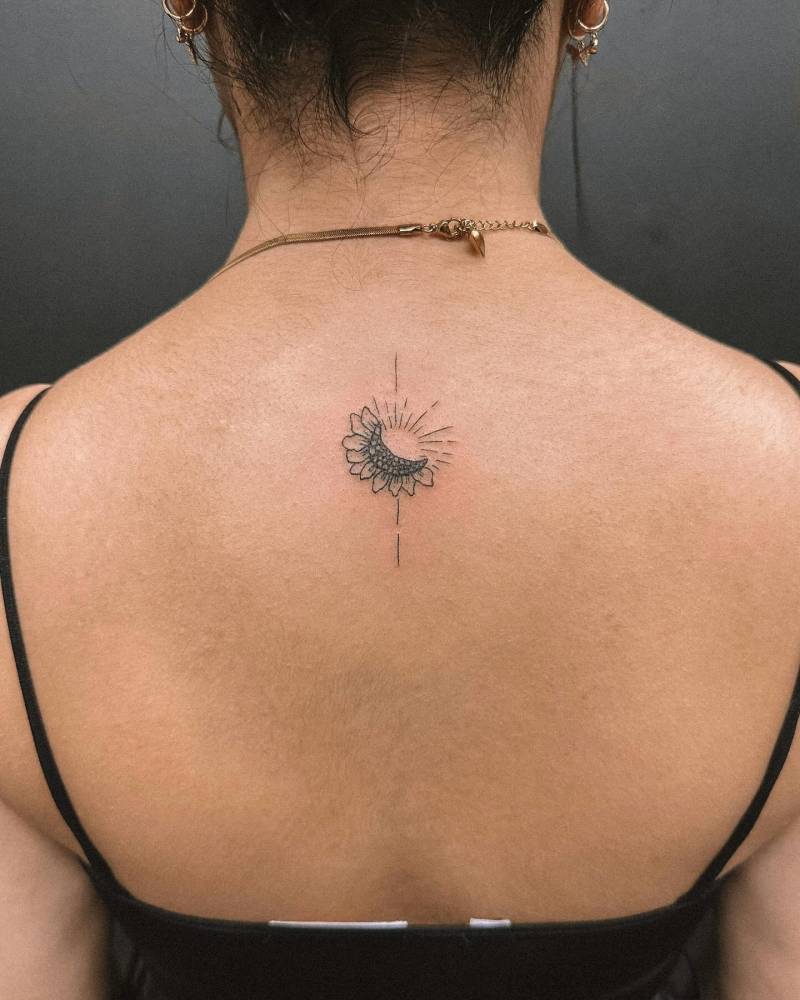 Sunflower and sun tattoo located on the upper back.