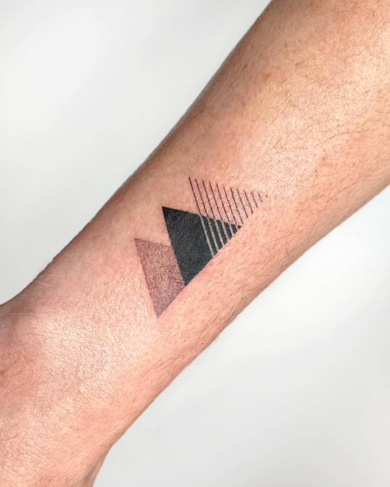 Triangles tattoo located on the wrist, geometric style.