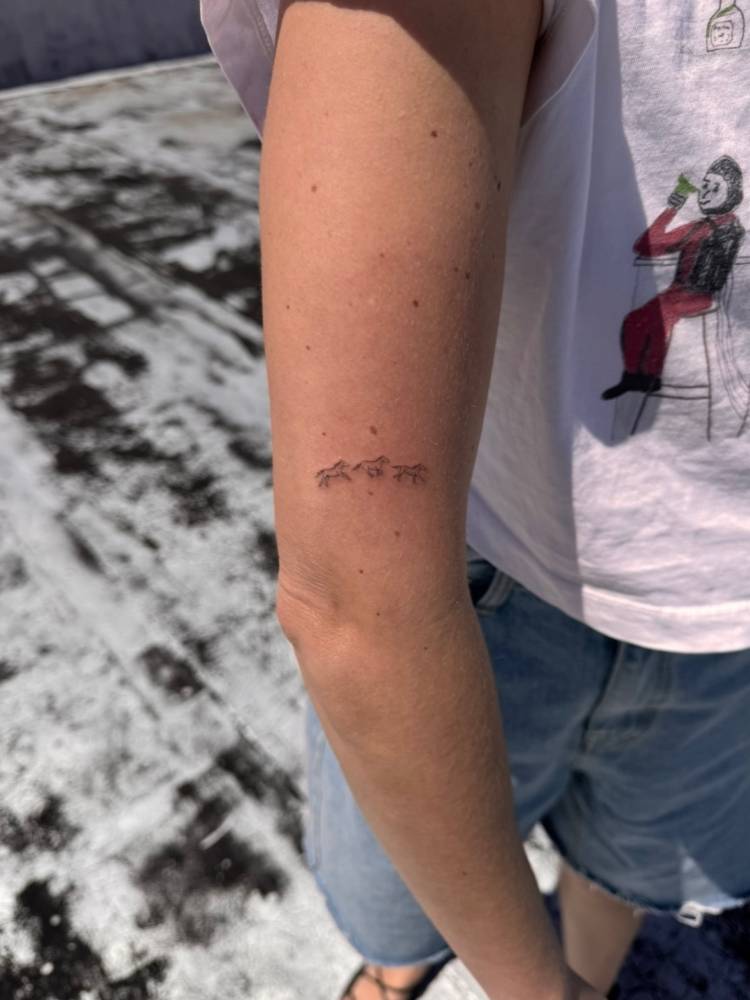 Single needle horse trio tattoo placed on the upper arm.