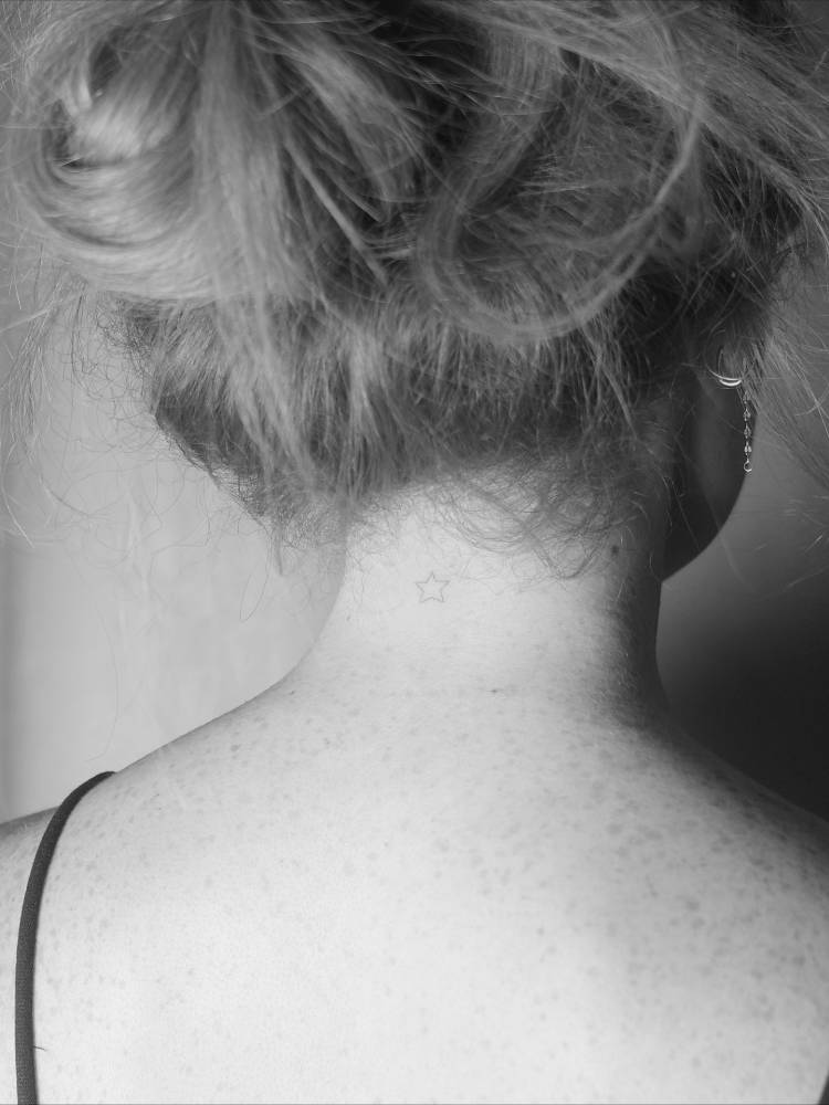 Minimalist little star tattoo located on the back of the neck.
