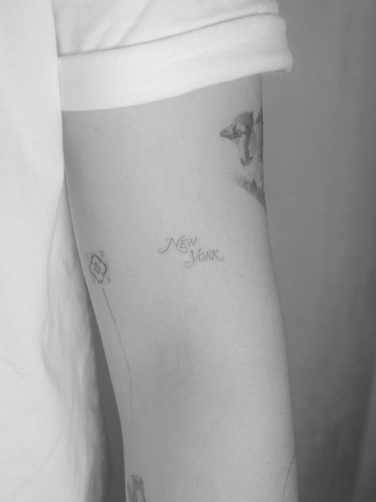 New York Magazine logo tattooed on the upper arm.