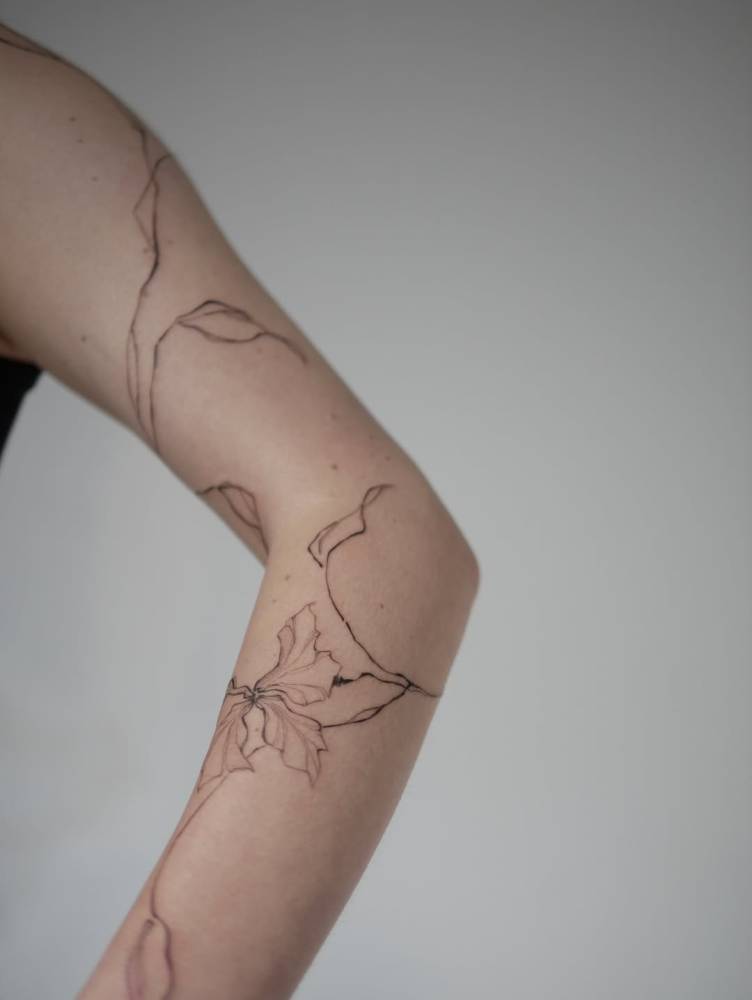 Floral design tattoo on the arm, illustrative style.