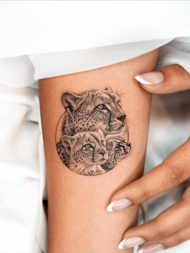 Micro-realistic style leopard family tattoo located on the inner forearm.