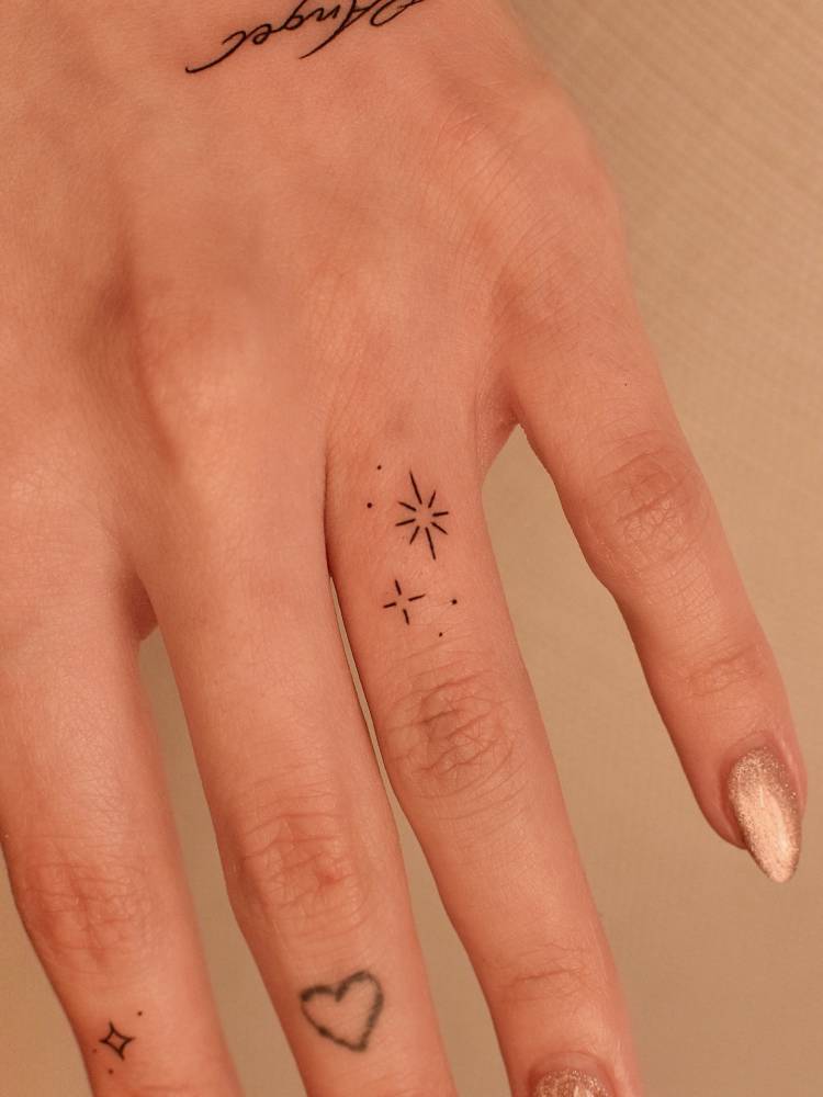 Sparkling stars tattoo in minimalistic style located on the finger.