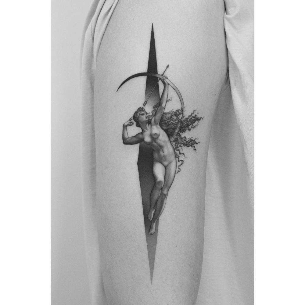 Artemis tattoo in classical style located on the upper arm.