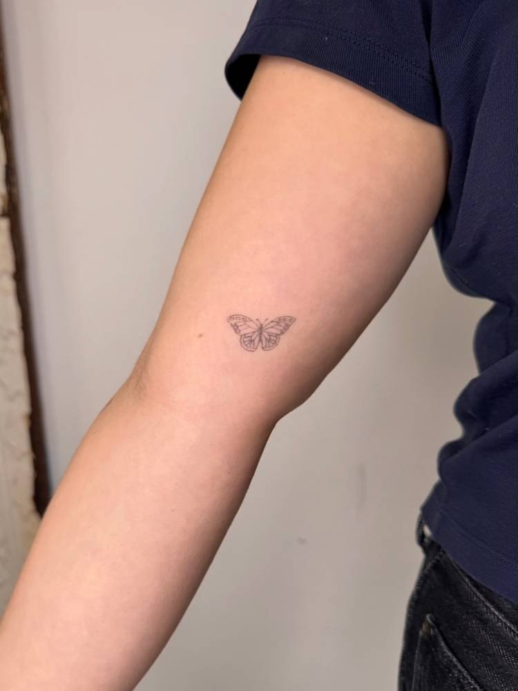 Single needle butterfly tattoo located on the inner arm.
