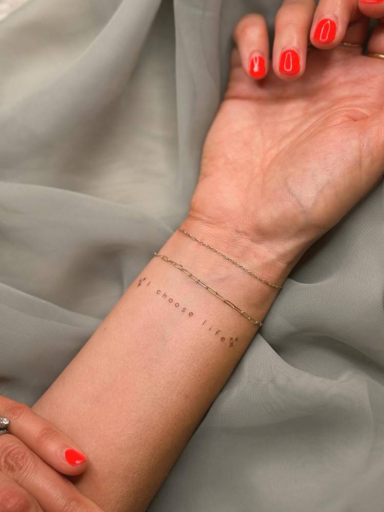 "I choose life" lettering tattoo located on the wrist.