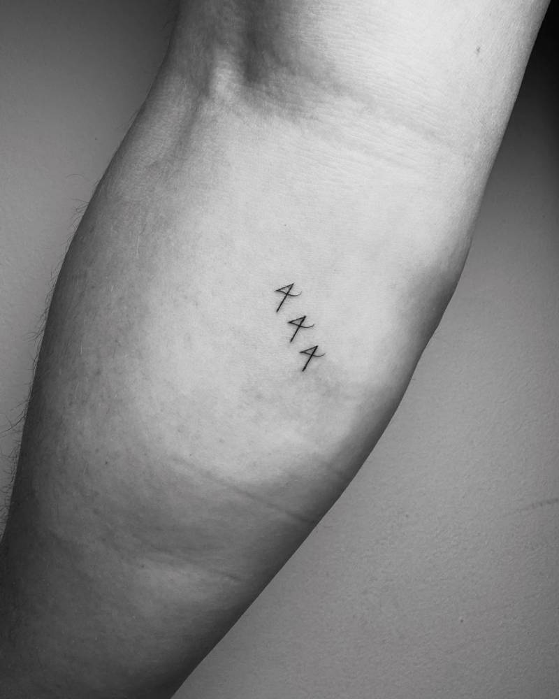 Angel number "444" tattoo located on the inner forearm.