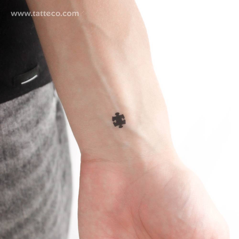 Black puzzle piece temporary tattoo located on the wrist.