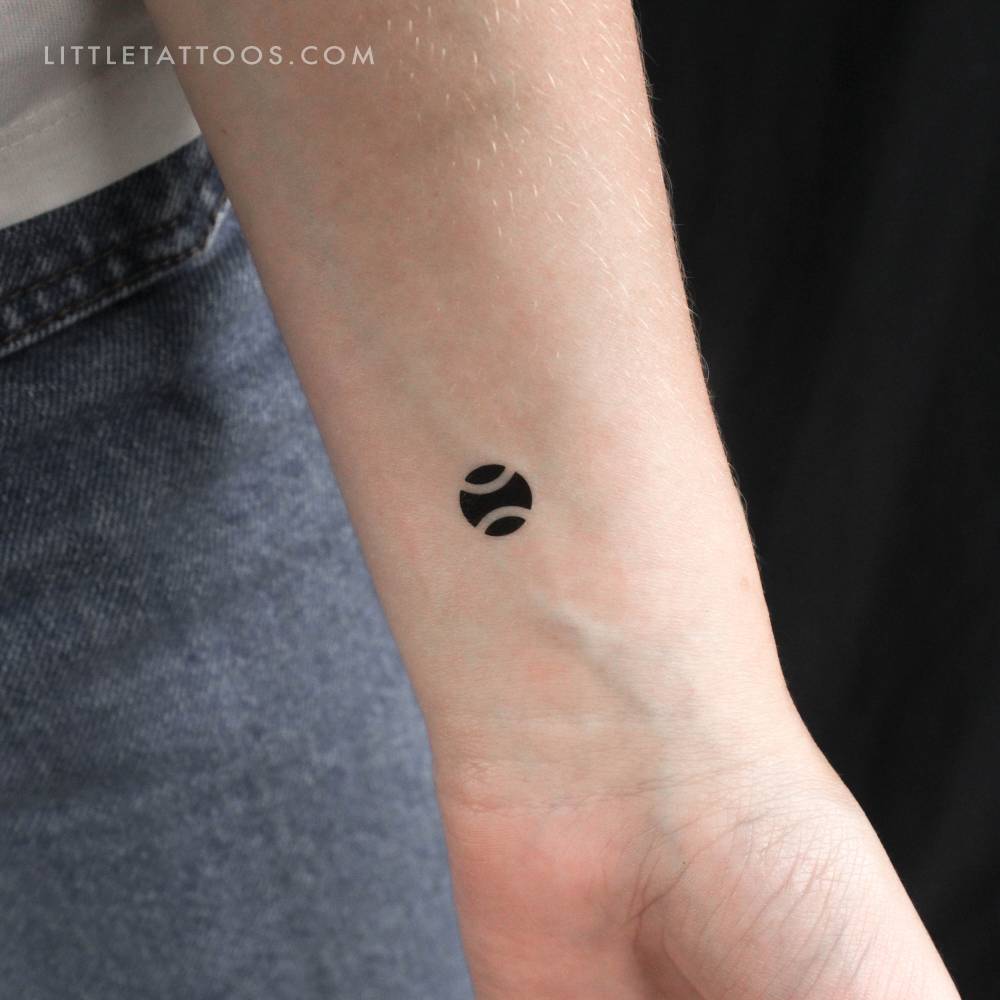 Black tennis ball temporary tattoo located on the wrist.