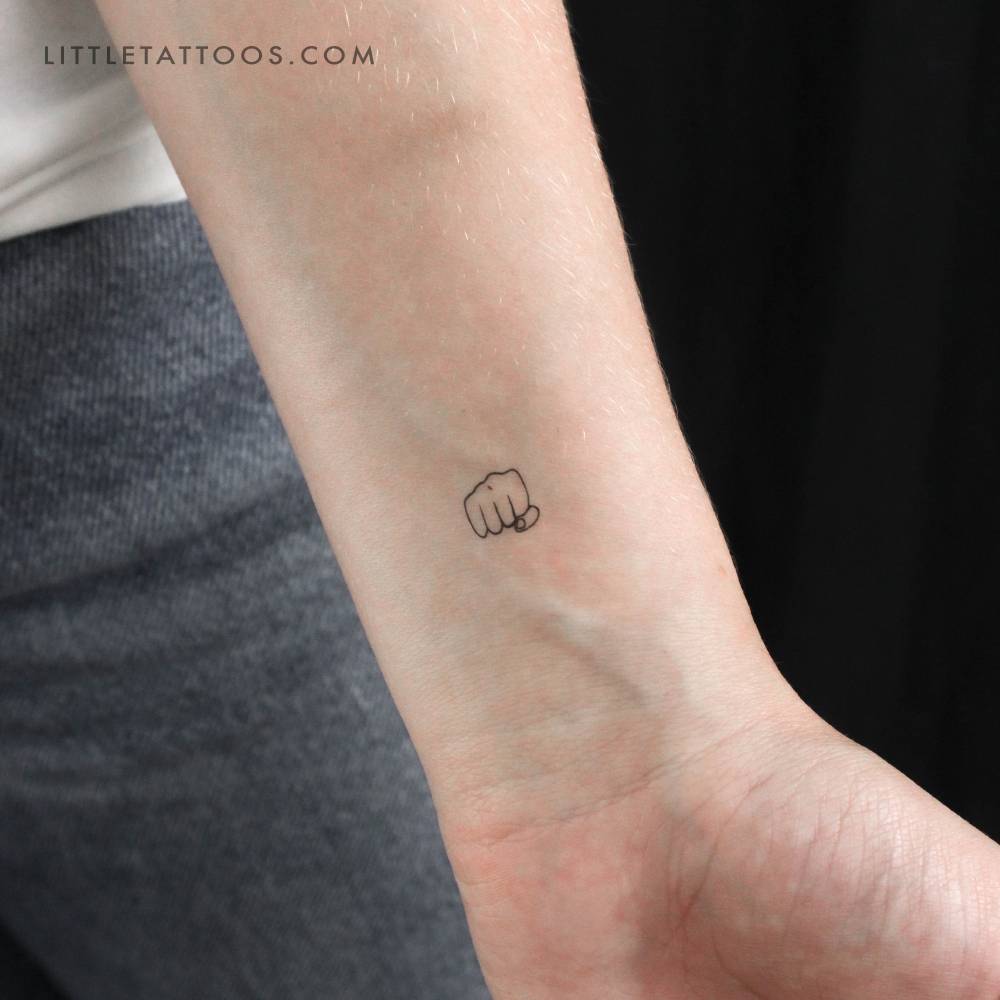 Fist temporary tattoo in minimalistic style placed on the wrist.
