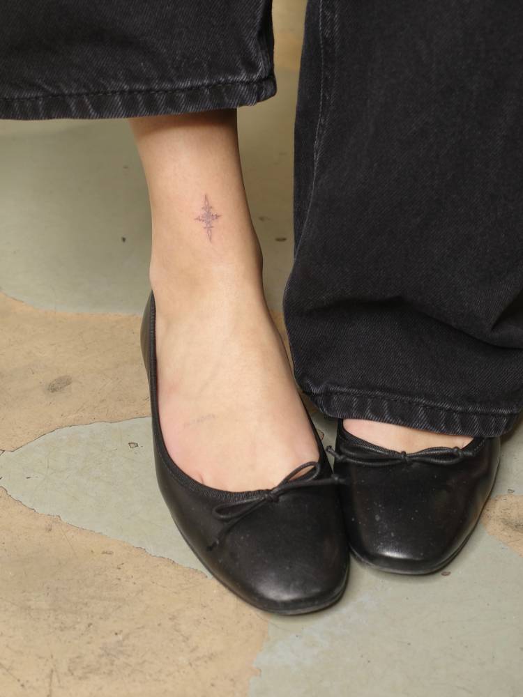 Ornamental tattoo in fine line style done on the ankle.