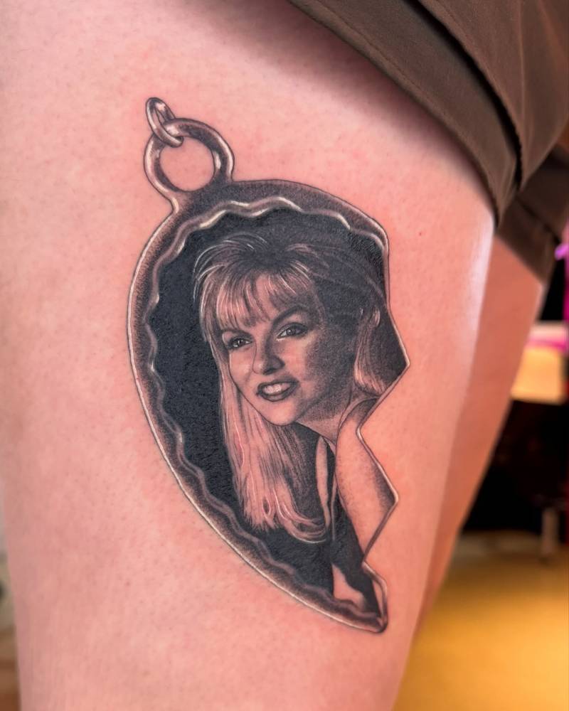 Laura Palmer pendant tattooed on the thigh, black and grey style.