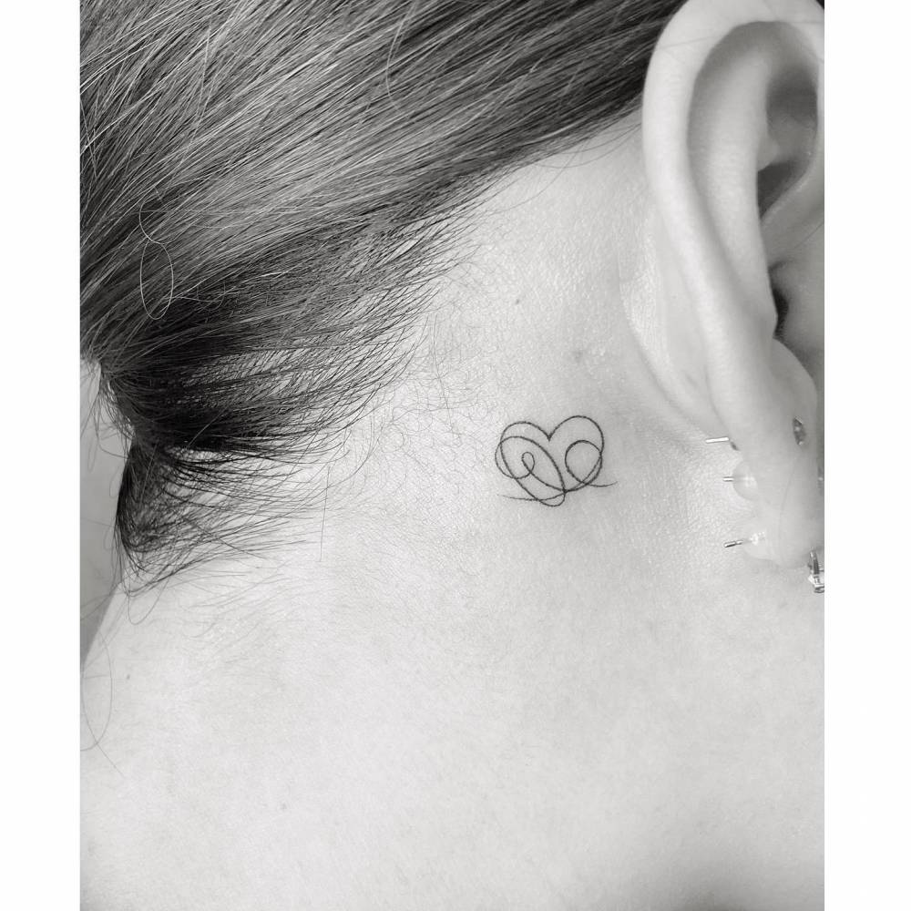 Abstract heart tattoo located behind the ear.