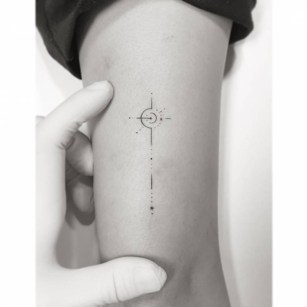 Compass rose tattoo located on the inner arm, minimalistic style.