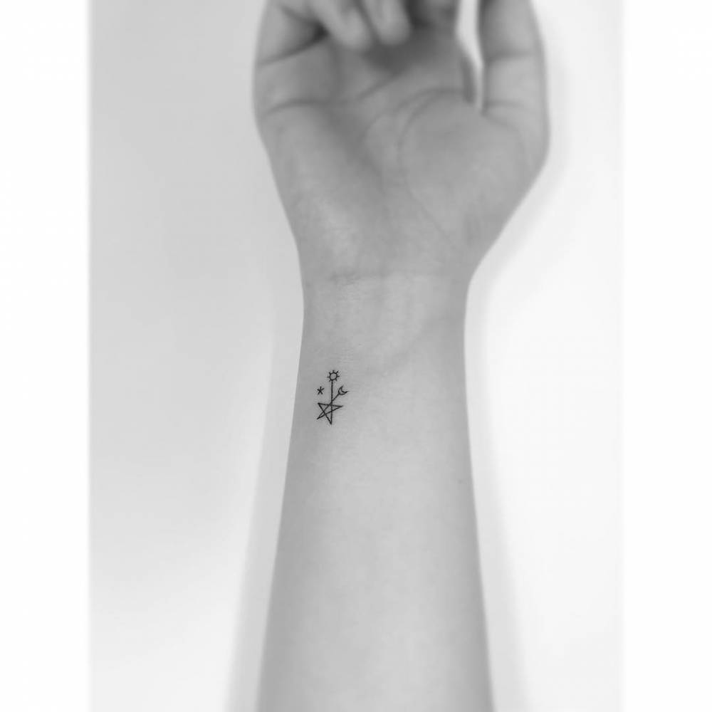 Sun and moon star tattoo located on the wrist, done in minimalistic style.