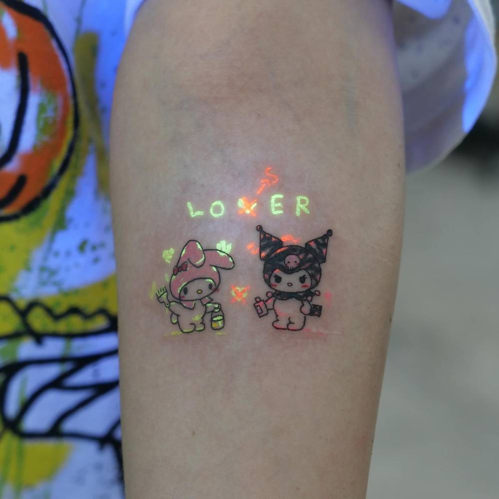 My Melody and Kuromi tattoo in cartoon style located on the inner forearm.