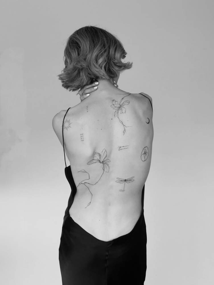 Illustrative style floral back composition tattoos.