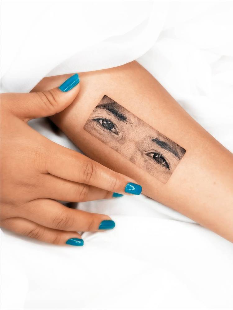 Micro-realistic style eyes tattoo located on the inner forearm.