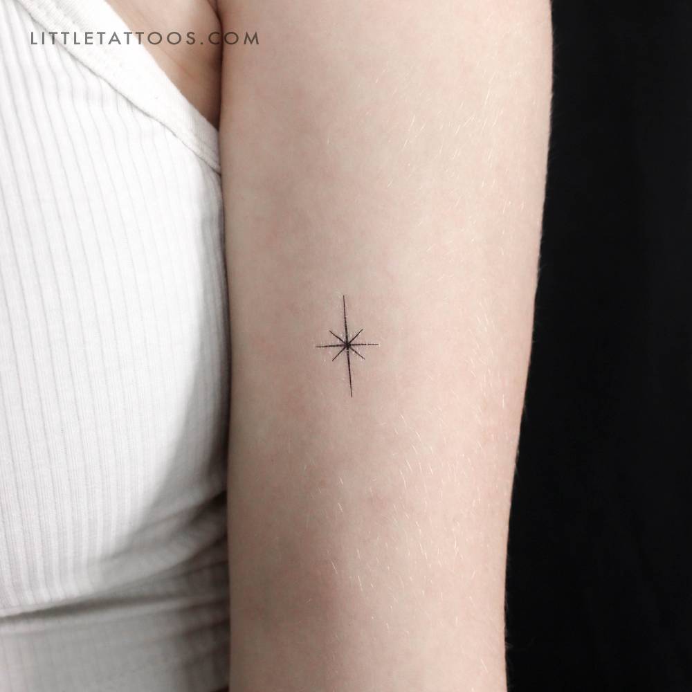 Small minimalist north star temporary tattoo located on the upper arm.