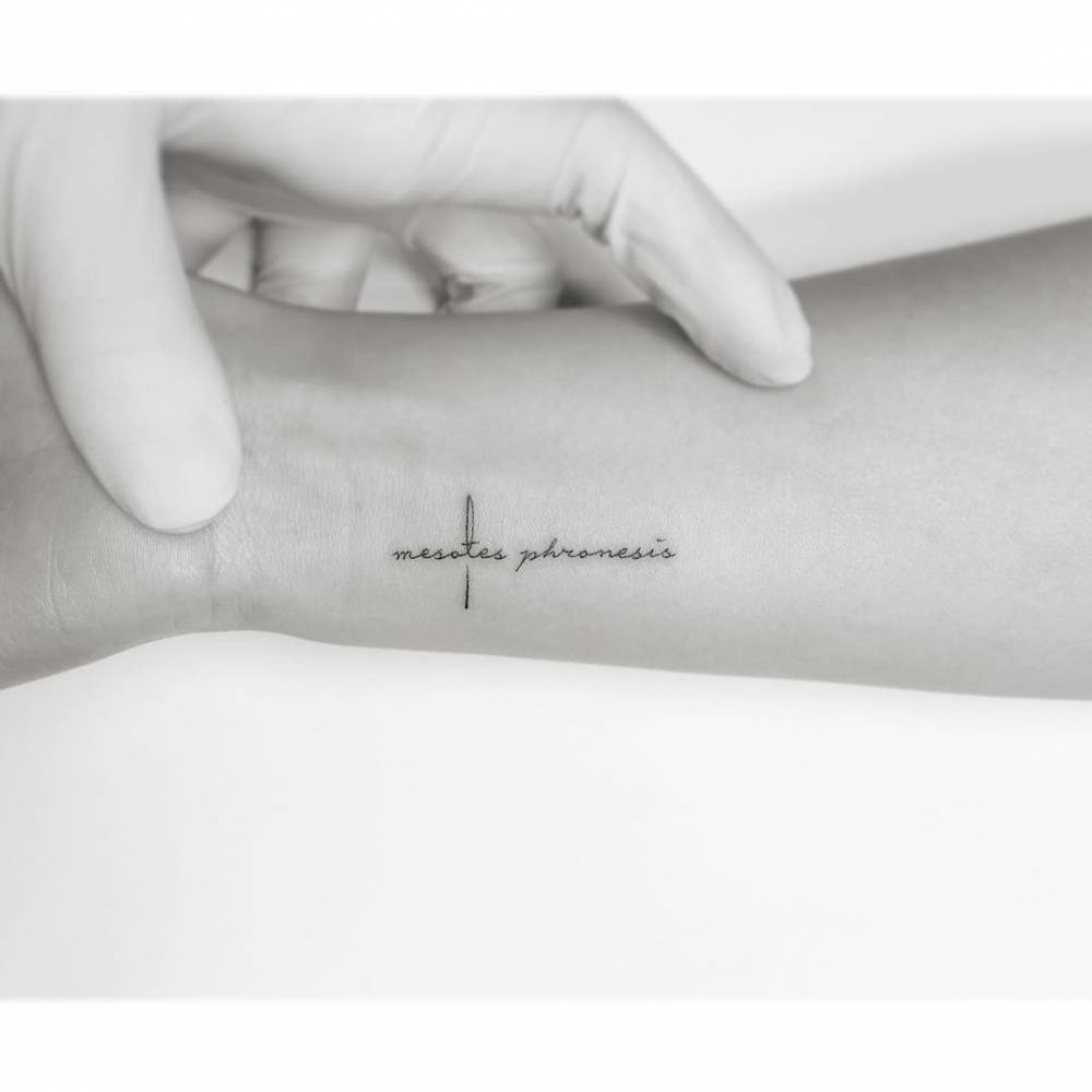 "Mesotes phronesis" lettering tattoo located on the wrist.