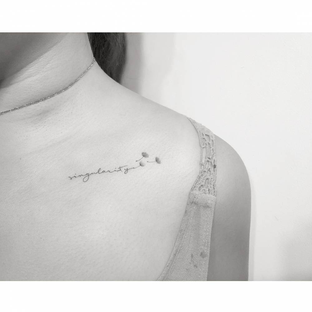 Word "singularity" and dandelion seeds tattooed on the collarbone.