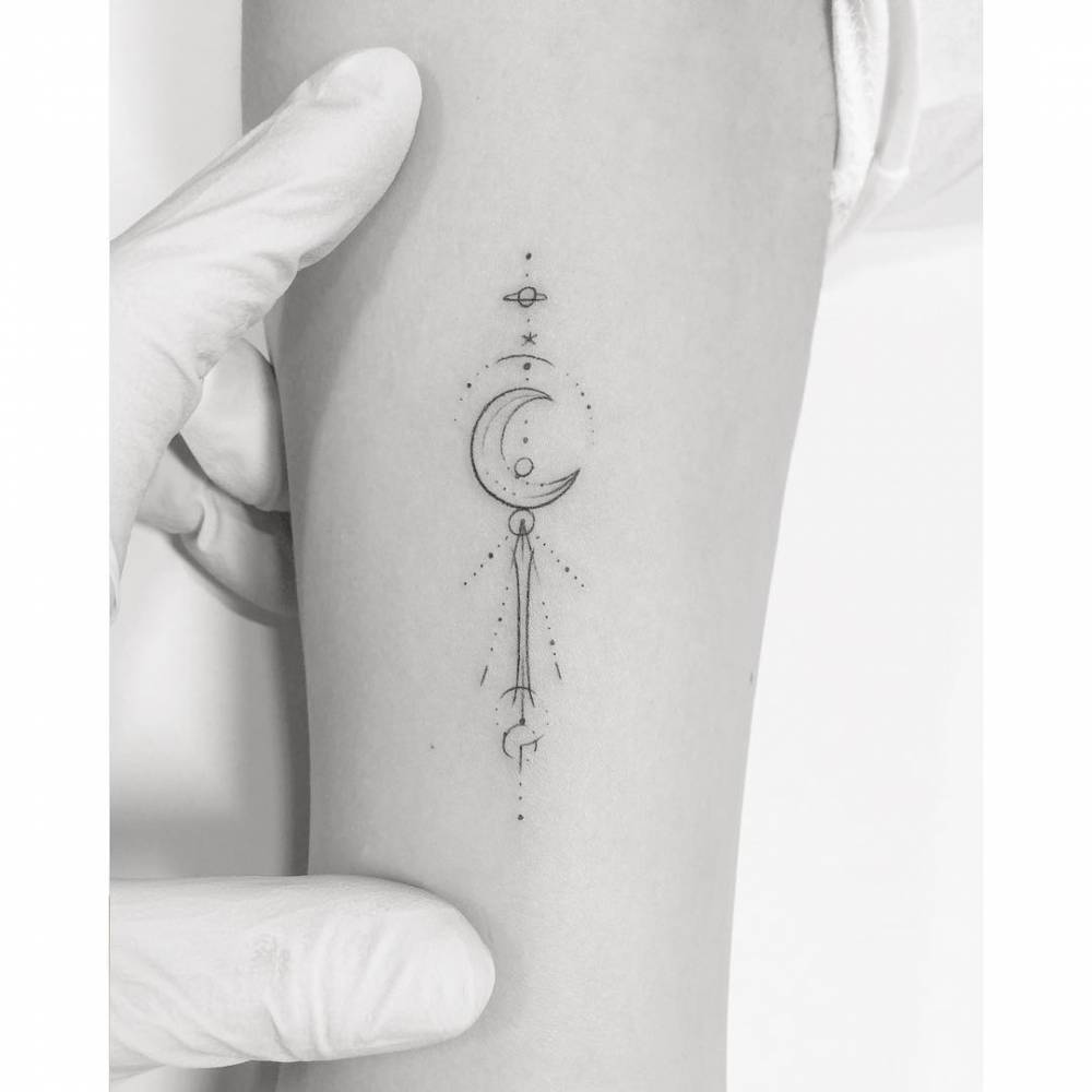 Moon Stick tattoo placed on the inner forearm, done in fine line style.