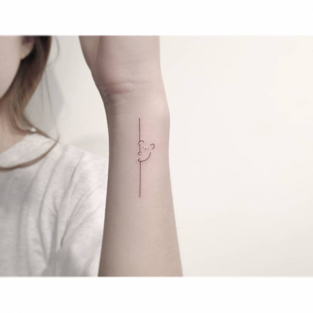 Tiny koala tattoo in minimalistic style located on the wrist.