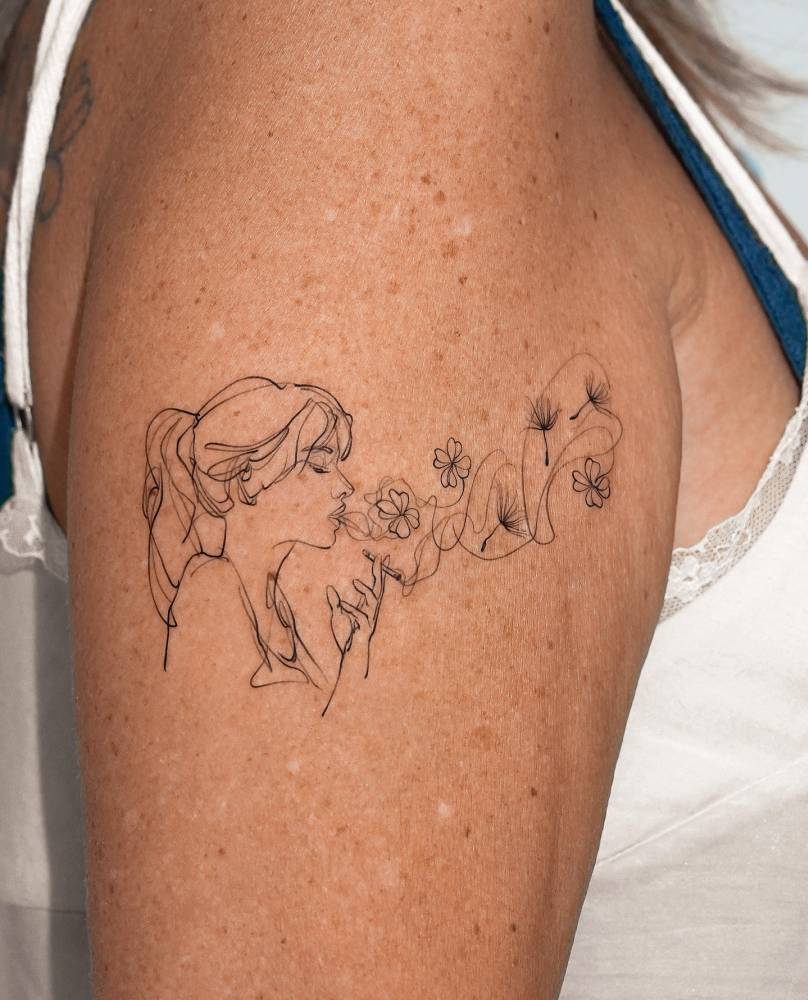 Sketch work style smoker and flowers tattoo located on the upper arm.