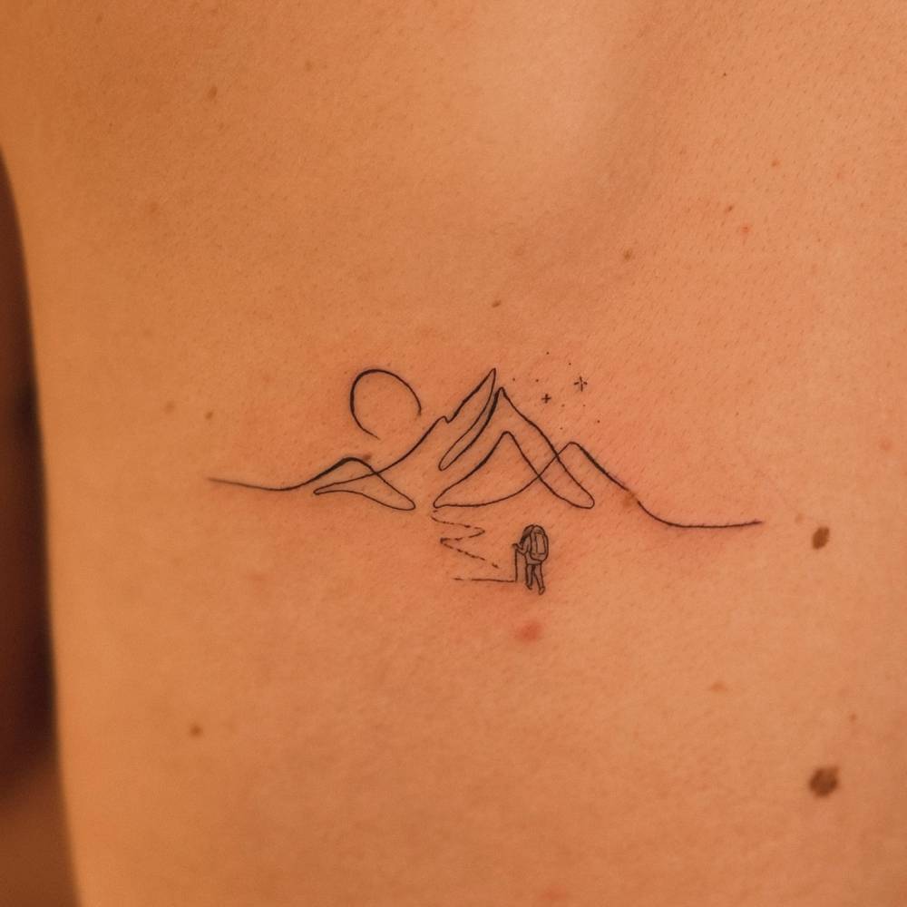 Continuous line mountain tattoo located on the back.
