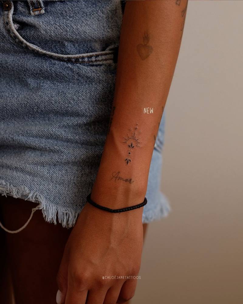 Ornamental design tattooed on the wrist, fine line style.