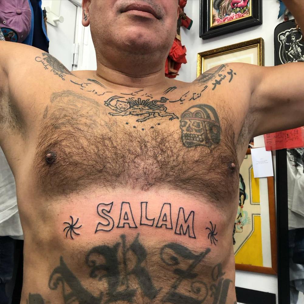 Lettering tattoo of the word "salam" located on the stomach.