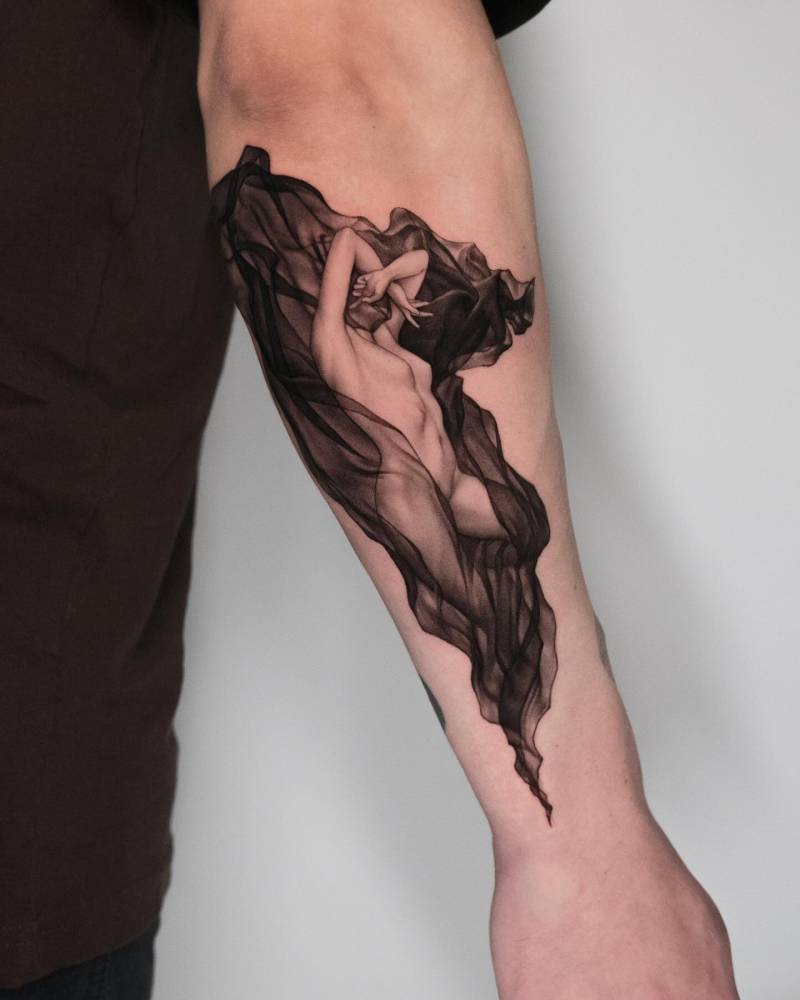 Classical style nude woman tattoo located on the forearm.