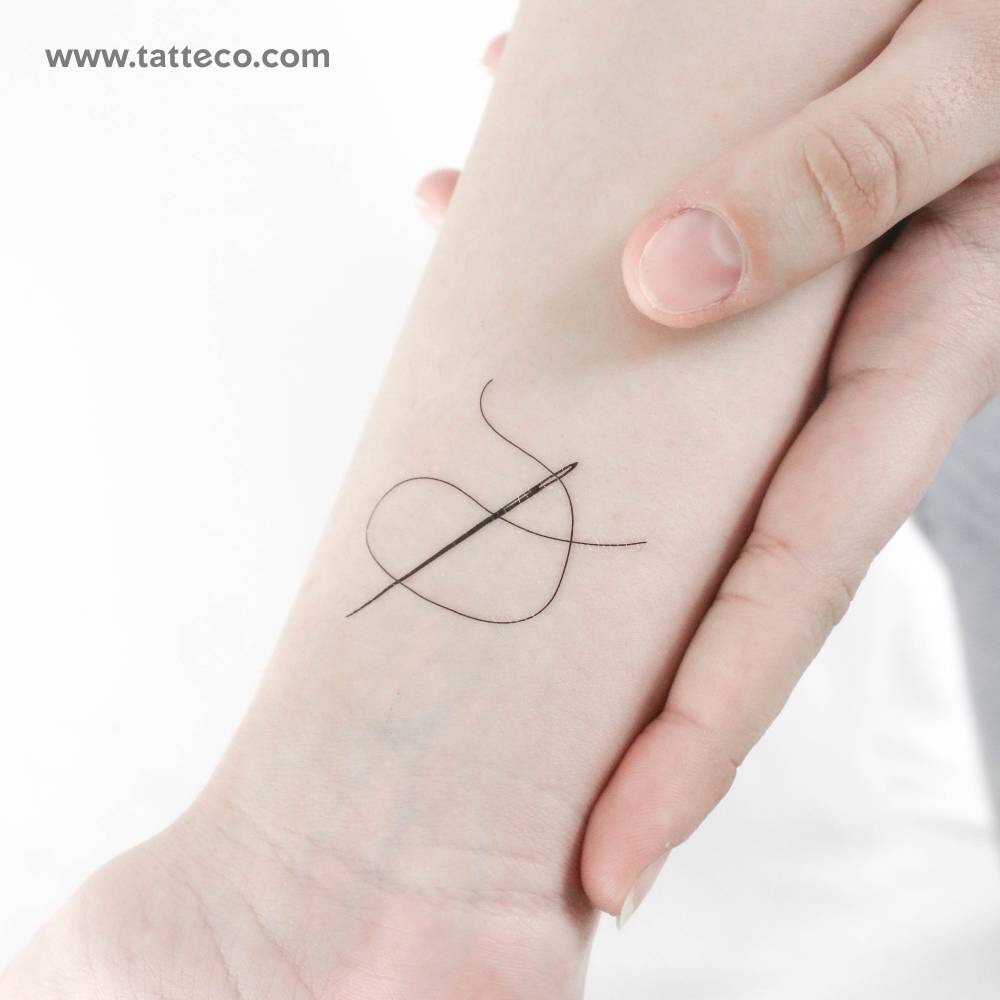 Needle and thread temporary tattoo located on the wrist.
