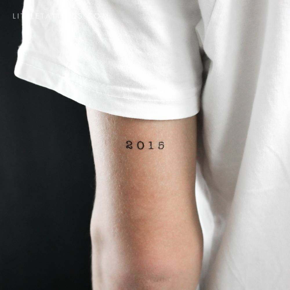 "2015" birth year temporary tattoo located on the tricep.