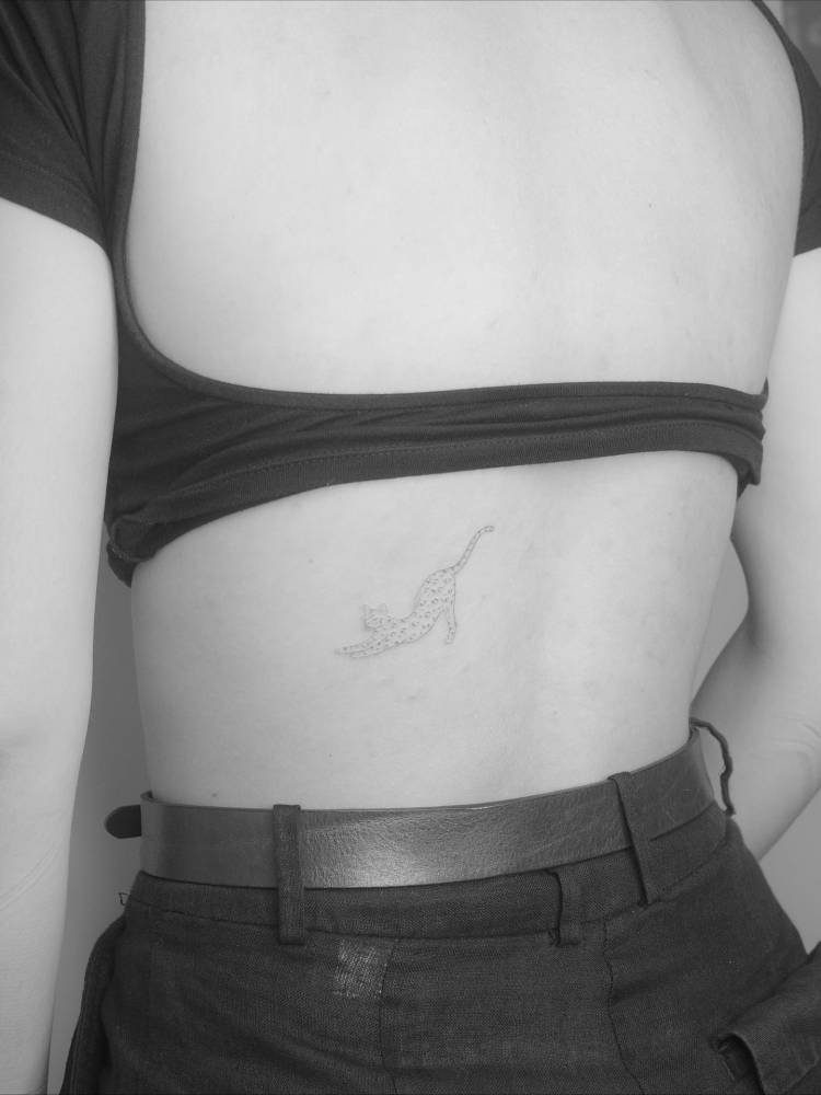 Leopard tattoo in fine line style located on the lower back.