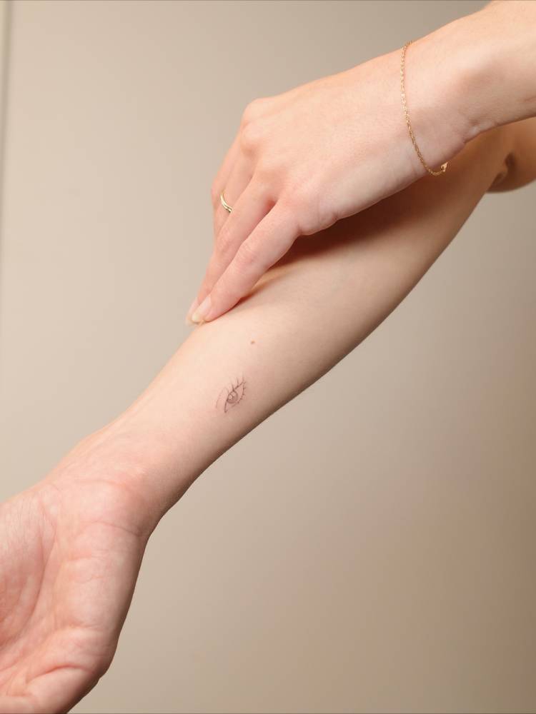 Fine line style eye tattoo located on the wrist.