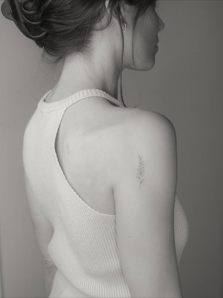 Fine line style flowers tattooed on the shoulder.