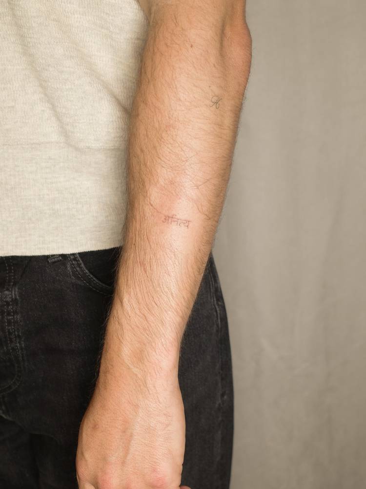 Sanskrit lettering tattoo located on the forearm.