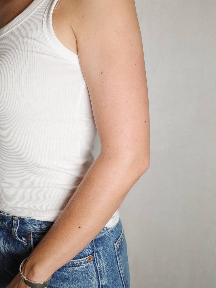 Tiny minimalist hearts tattooed on the upper arm and forearm.
