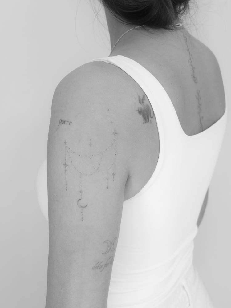 Ornamental design tattooed on the upper arm, fine line style.